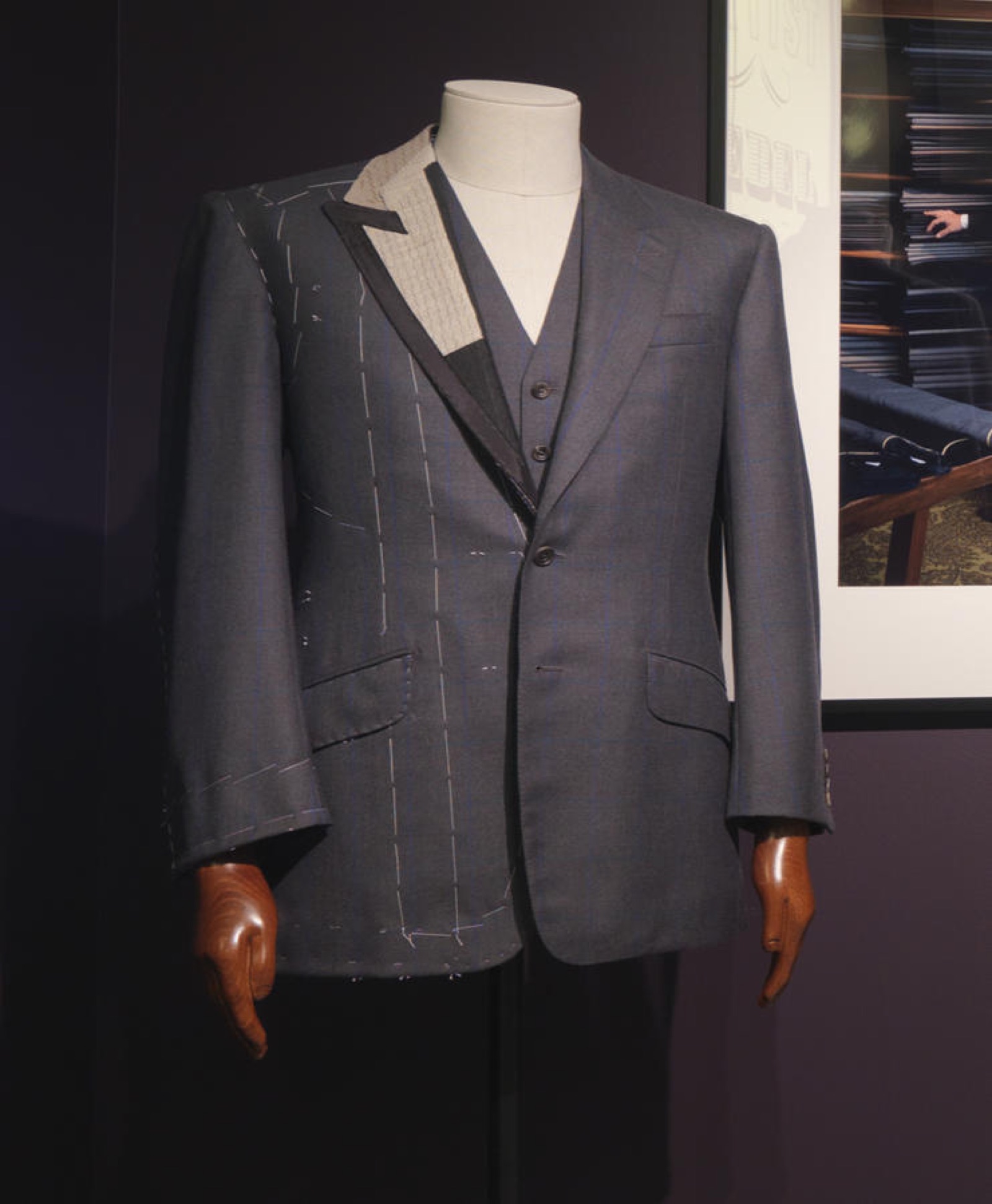 A bespoke jacket in progress: one side finished, the other still showing its canvas and white basting thread